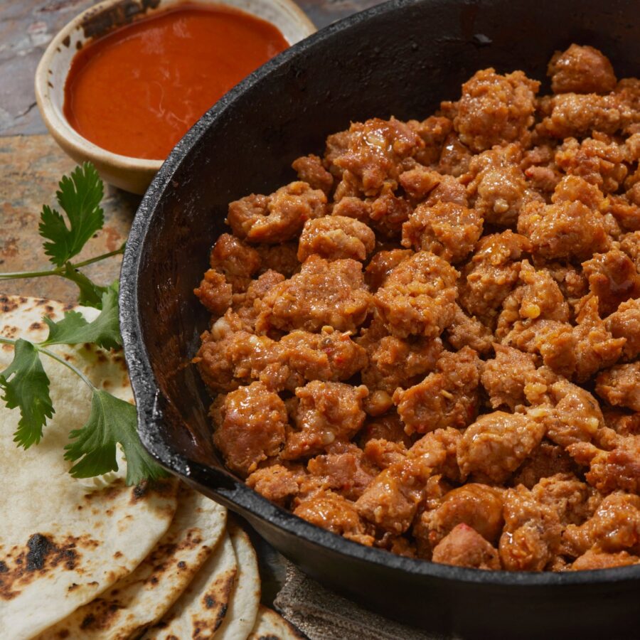 Cooked and Crumbled Chorizo in a skillet with tortillas next to it