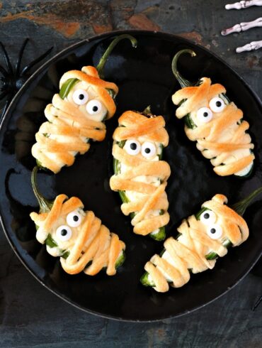 Overhead image of Mummy Jalapeno Poppers on a white plate