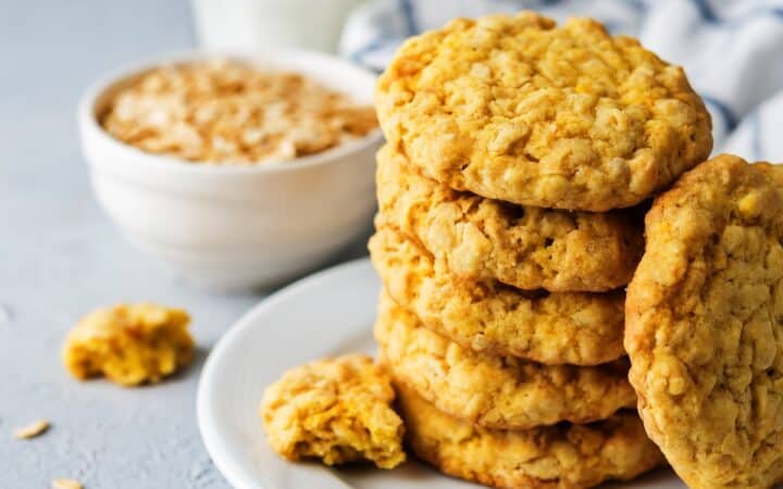 Pumpkin Oatmeal Cookies on a white plate with oats and milk in the background