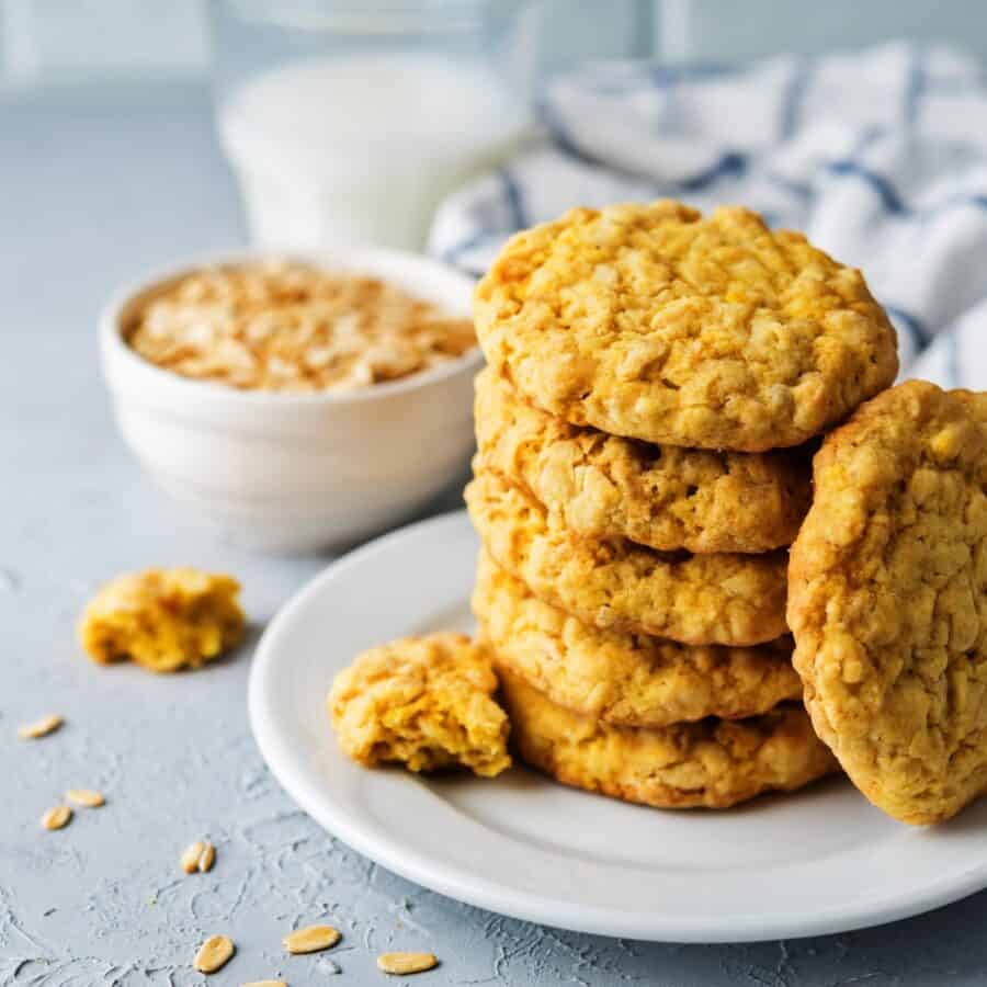 Pumpkin Oatmeal Cookies on a white plate with oats and milk in the background