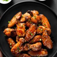 Overhead image of Sticky Chicken Wings on a black plate