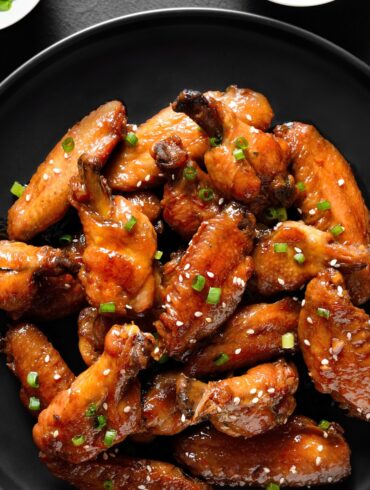 Overhead image of Sticky Chicken Wings on a black plate