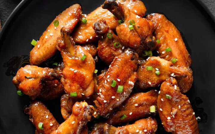 Overhead image of Sticky Chicken Wings on a black plate