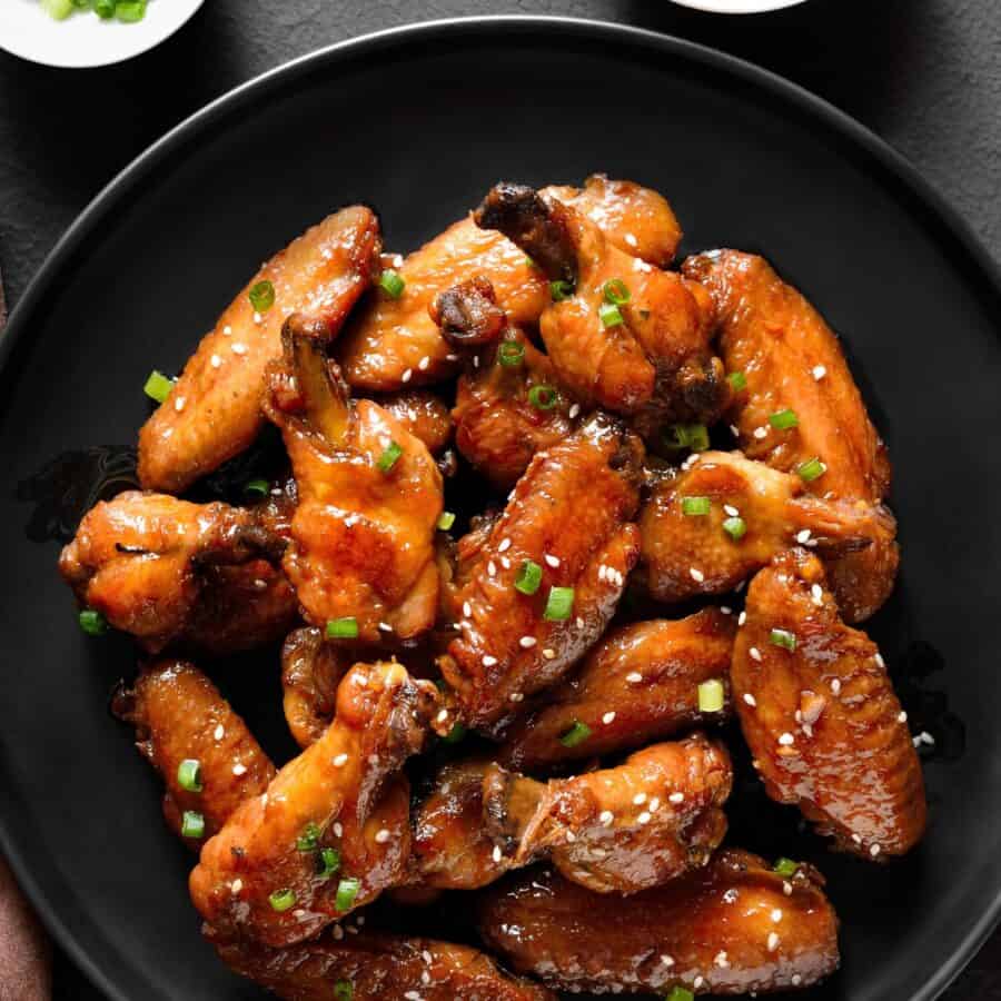 Overhead image of Sticky Chicken Wings on a black plate