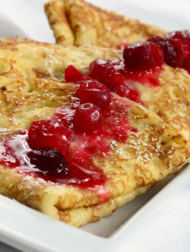 Close up image of Swedish Pancakes with ligonberry jam on top