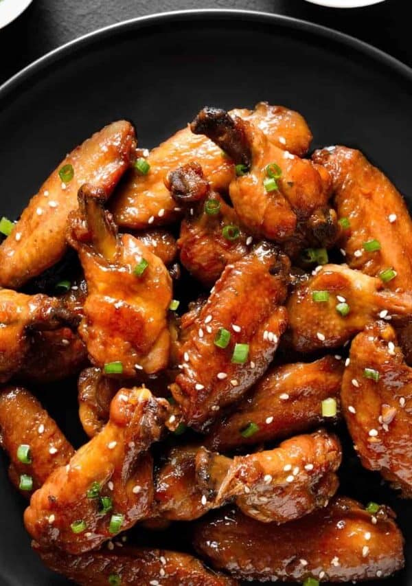 Overhead image of Sticky Chicken Wings on a black plate