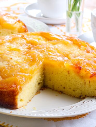 Close up image of an Apple Upside Down Cake with a slice cut out of it