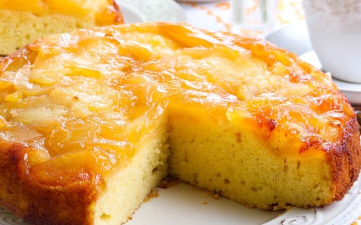 Close up image of an Apple Upside Down Cake with a slice cut out of it