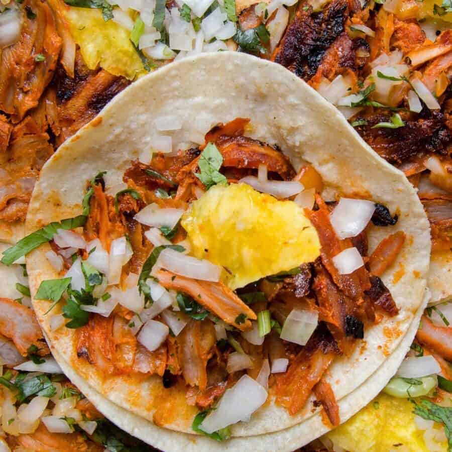 Close up image of Pork Al Pastor tacos on a decorative plate