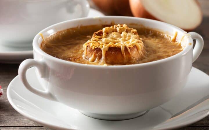 Close up image of Slow Cooker French Onion Soup in a white bowl