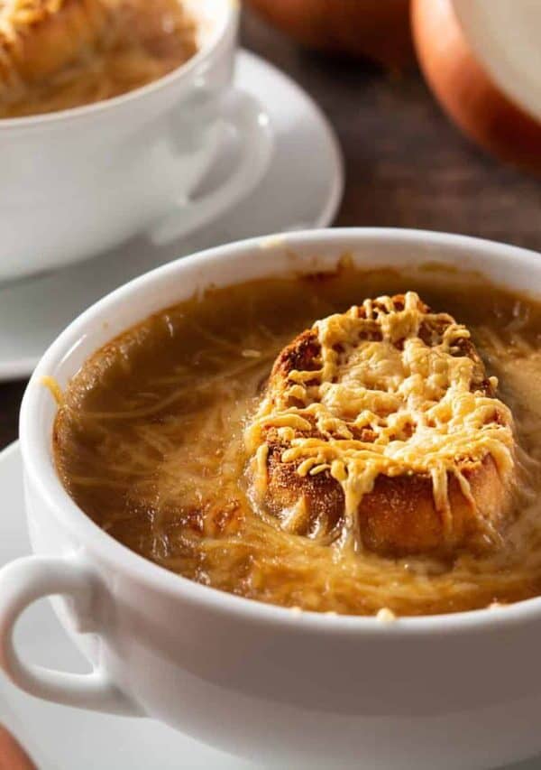 Two white bowls with handles full of Slow Cooker French Onion Soup