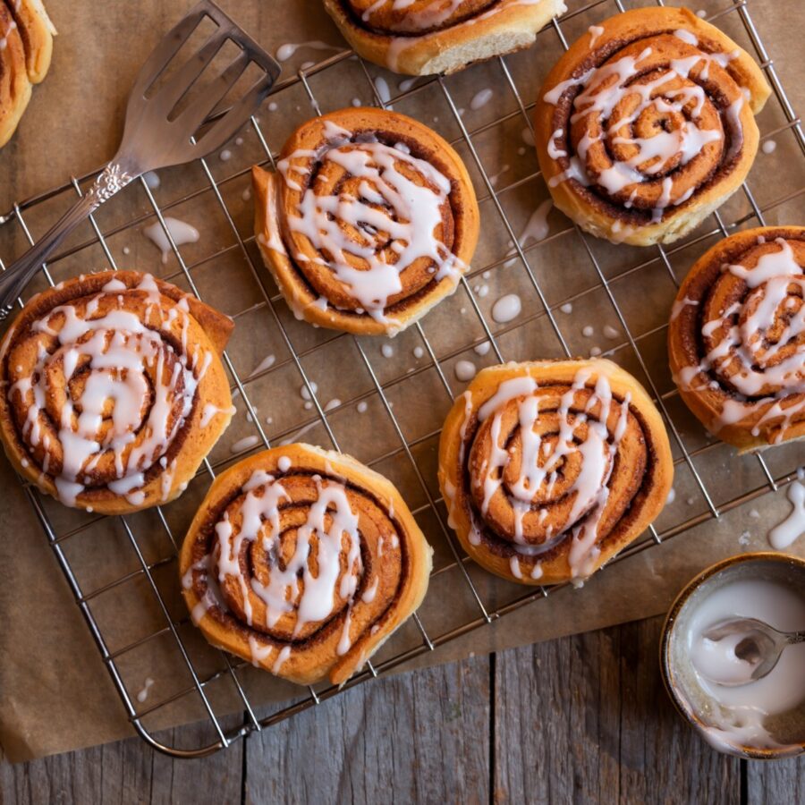 Chocolate Cinnamon Rolls on a cooling rack covered in glaze