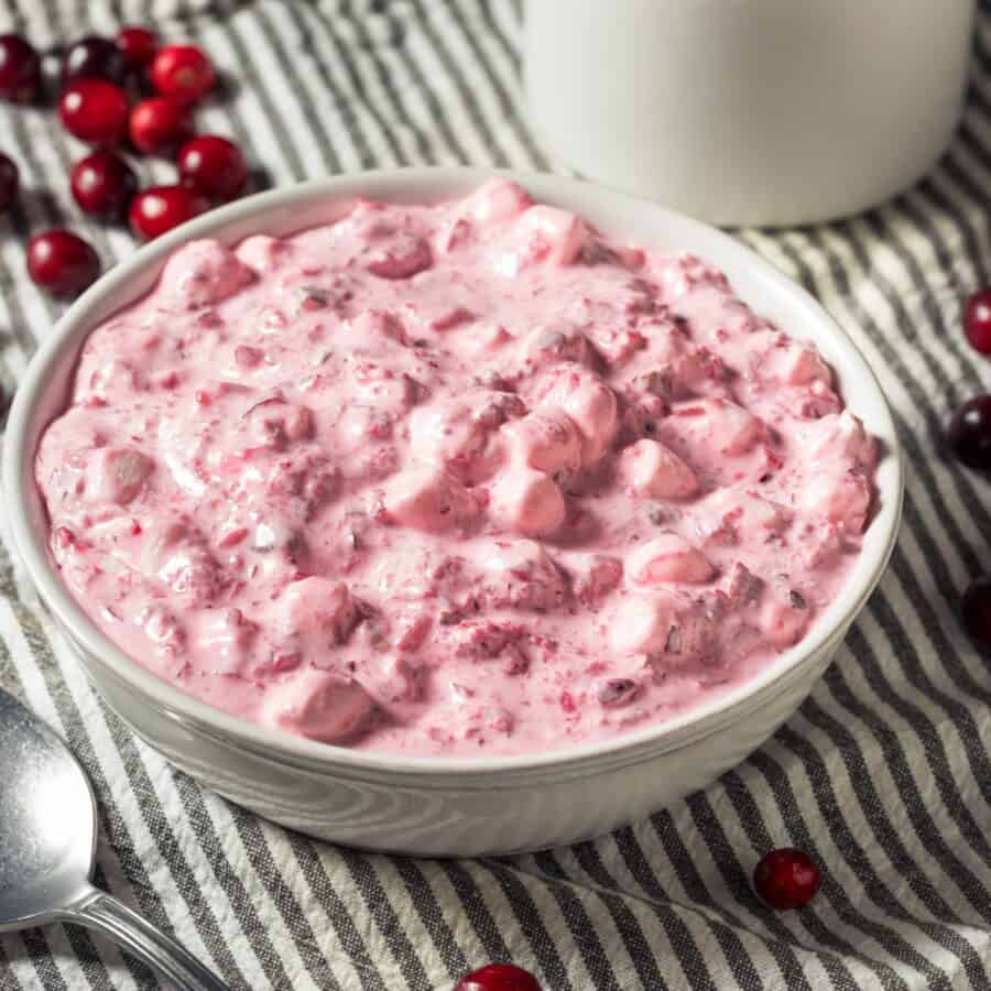 Cranberry Salad in a white bowl on a striped surface
