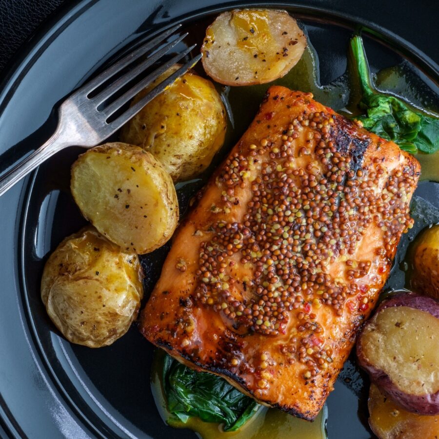 Overhead image of Dijon Salmon on a plate with baby potatoes and greens