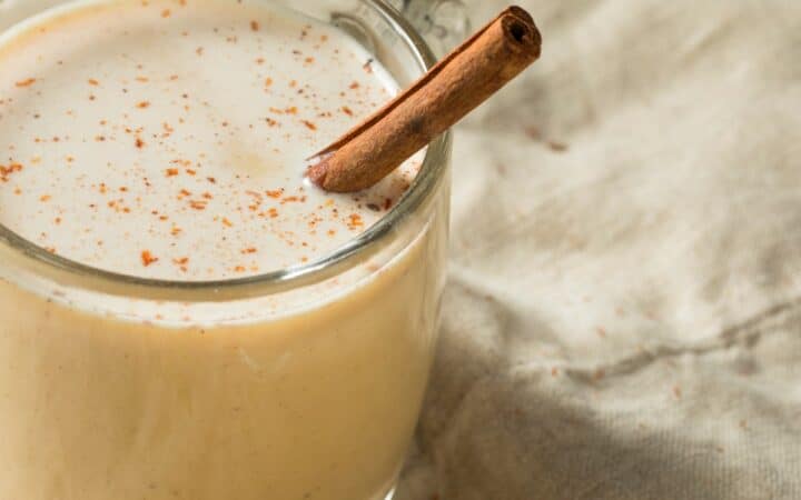 image of a mug of Eggnog with a cinnamon stick in it