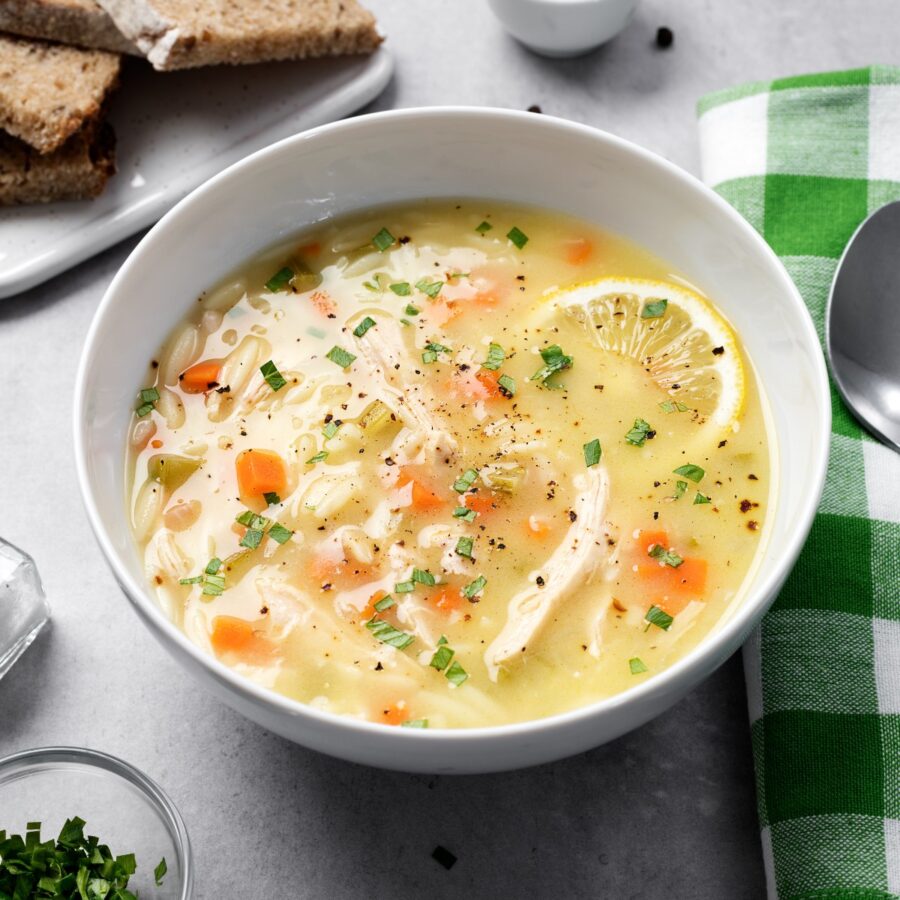 Close up image of Lemon Chicken Orzo Soup in a white bowl