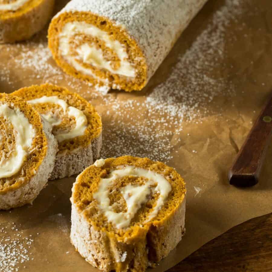 A pumpkin roll with slices cut from it