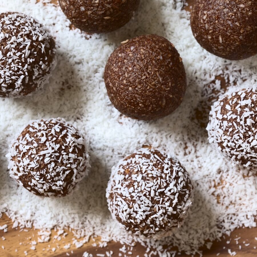 Overhead image of Rum Balls being rolled in shredded coconut