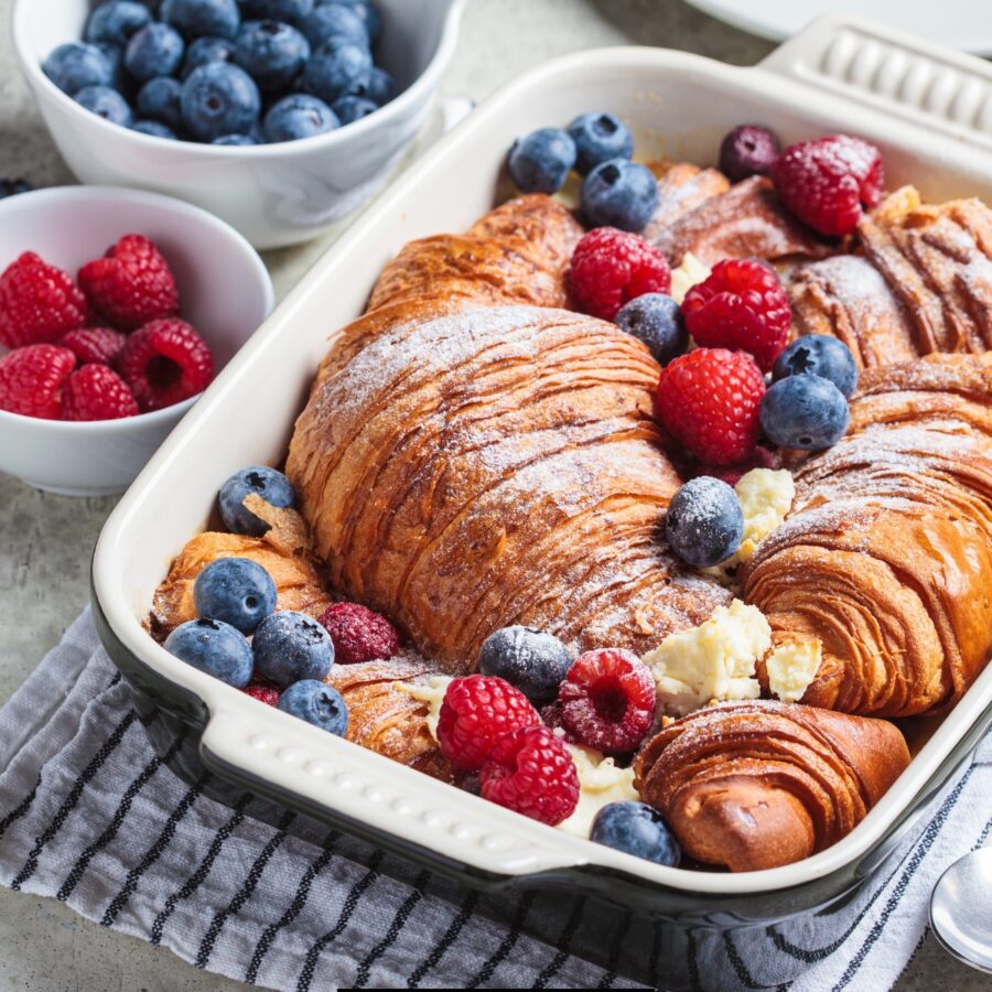 Croissant French Toast Casserole in a baking dish with berries to garnish