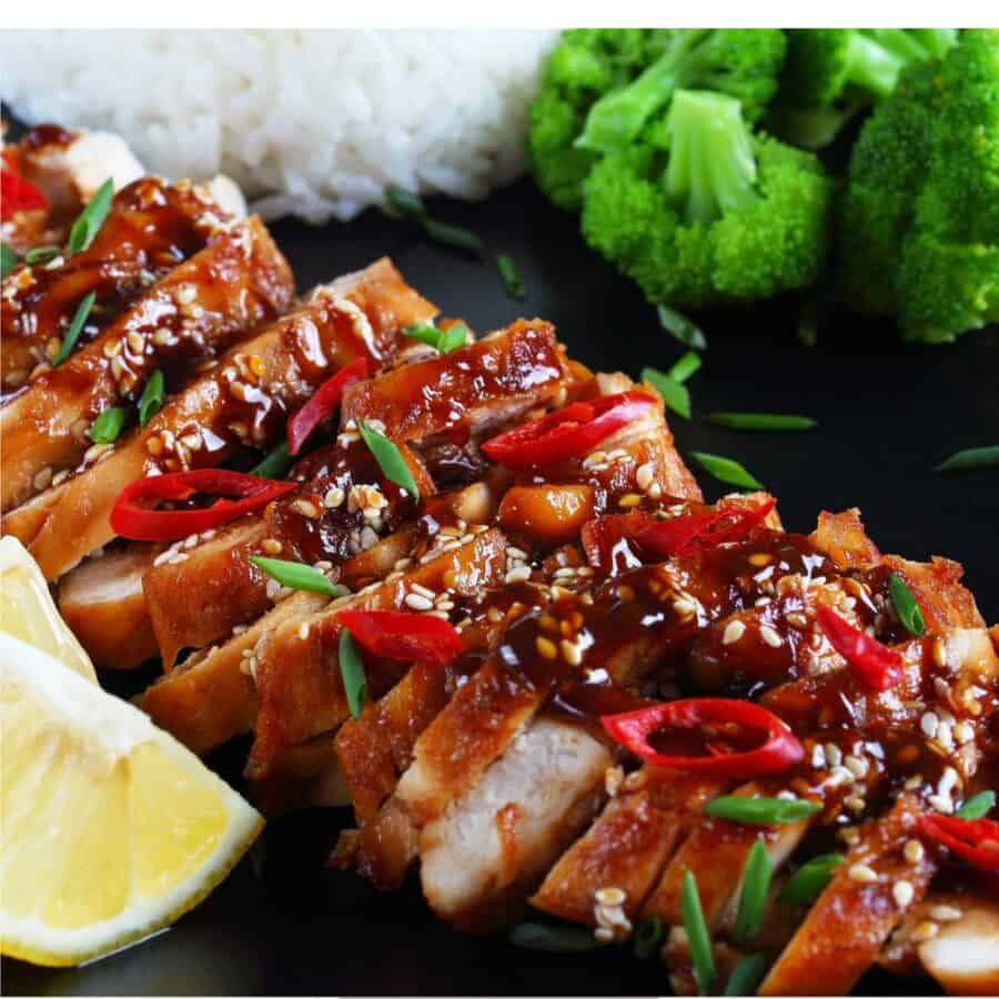Grilled Teriyaki Chicken sliced on a black plate