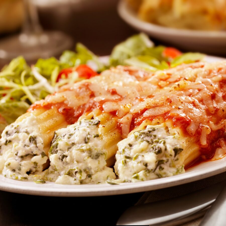 Three Cheese Manicotti on a plate with a side salad