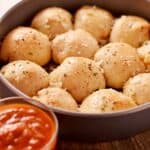 Pizza Balls in a round baking dish with a side of marinara dipping sauce - 8