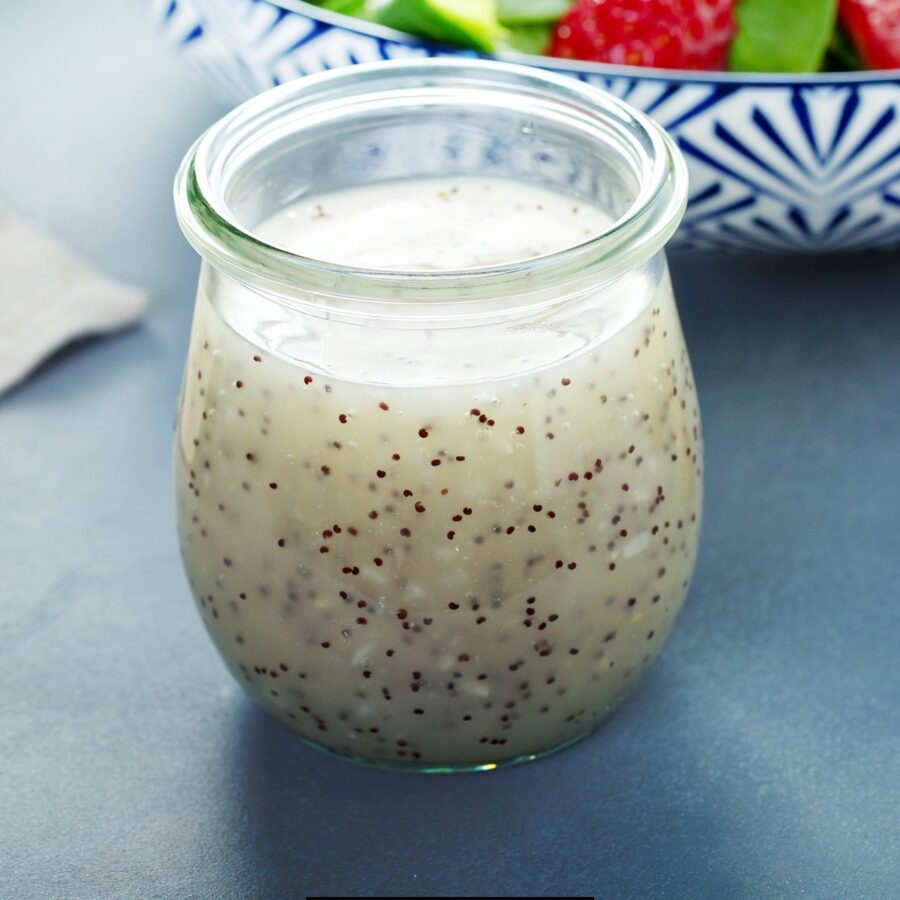 Poppyseed Dressing in a glass jar on a blue surface