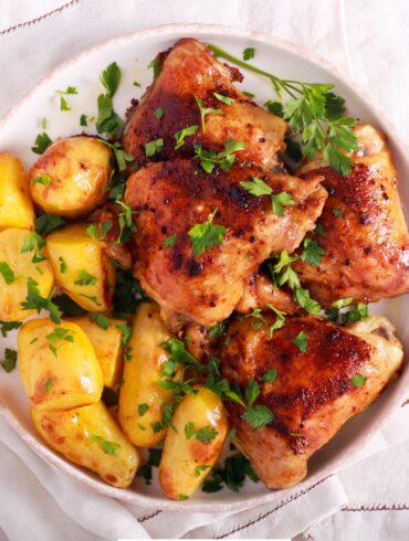 Overhead image of roasted chicken and potatoes on a white plate