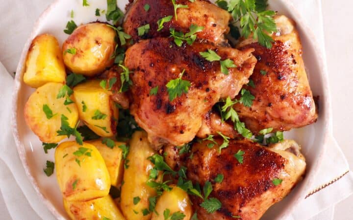 Overhead image of roasted chicken and potatoes on a white plate