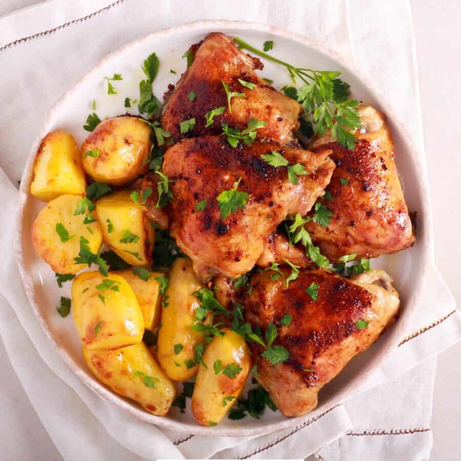 Overhead image of roasted chicken and potatoes on a white plate