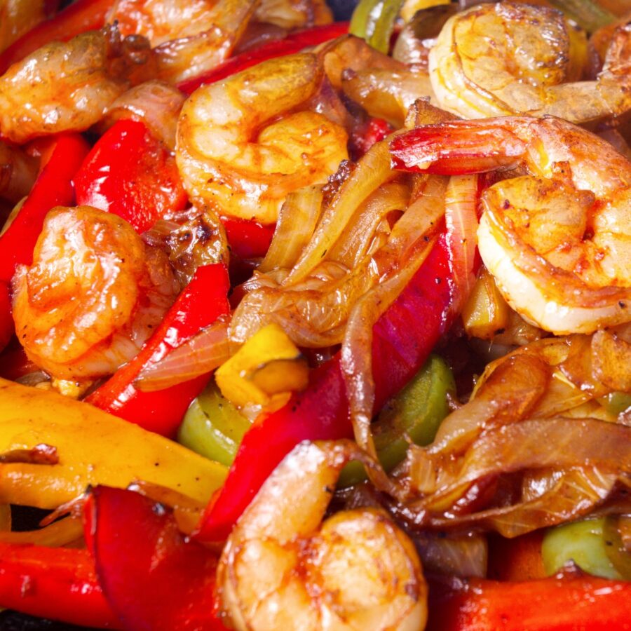 Image of roasted onions, peppers, and shrimp to fill Sheet Pan Shrimp Fajitas