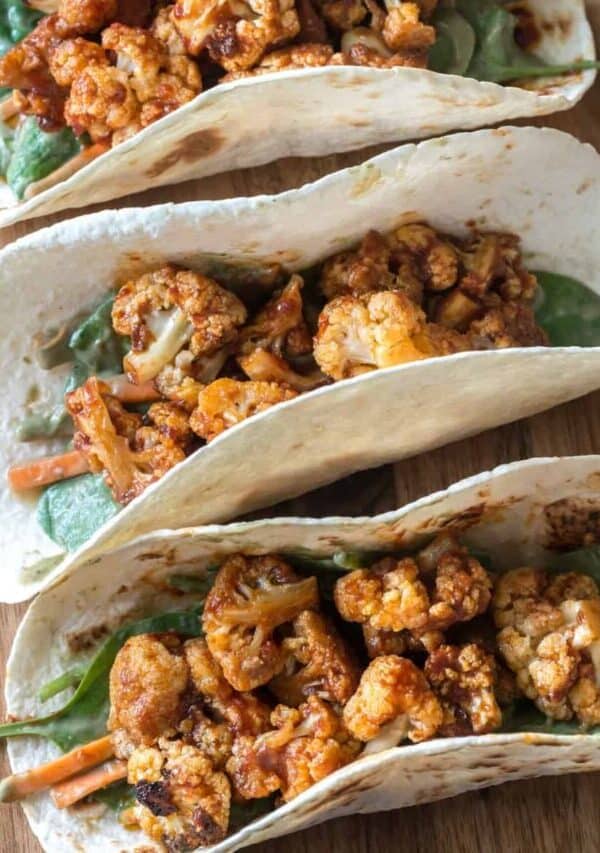 Overhead image of cauliflower tacos on a wooden cutting board