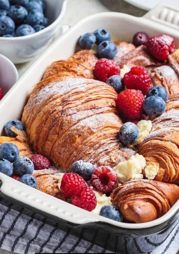 Croissant French Toast Casserole in a baking dish with berries to garnish