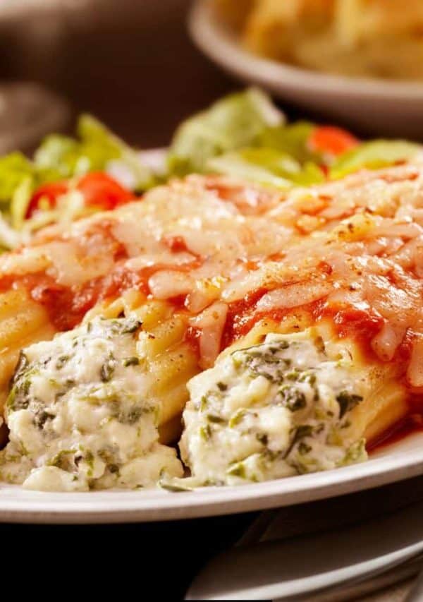 Three Cheese Manicotti on a plate with a side salad