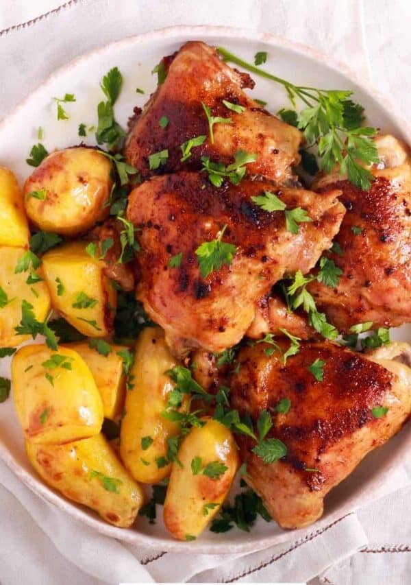 Overhead image of roasted chicken and potatoes on a white plate