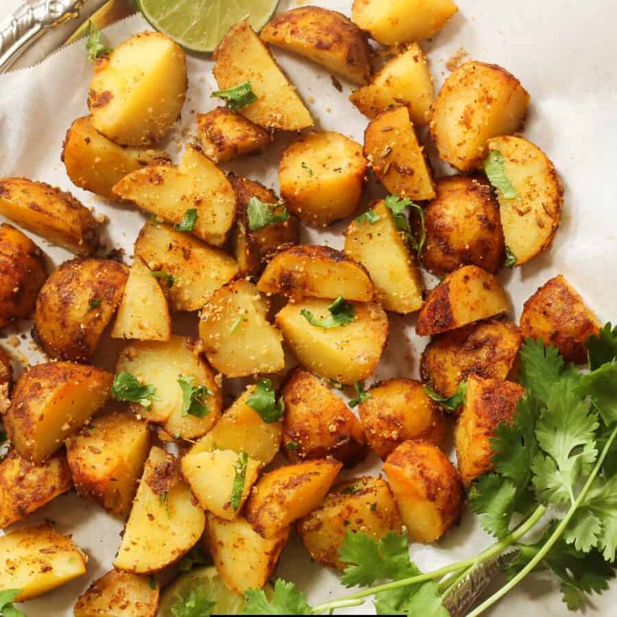 Overhead image of air fryer breakfast potatoes on a white plate with herbs