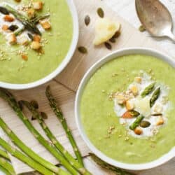 Overhead image of two bowls of asparagus soup