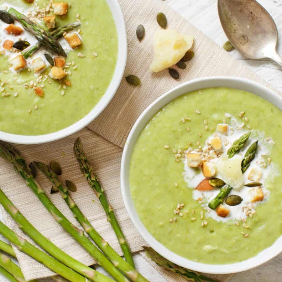 Overhead image of two bowls of asparagus soup