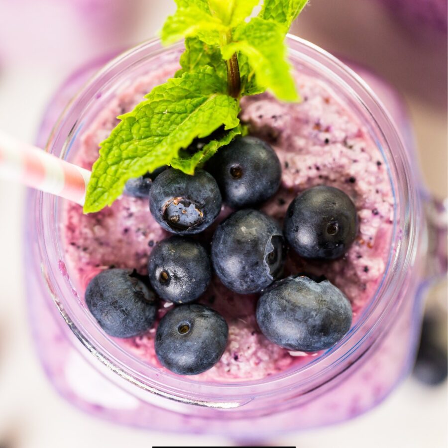 overhead image of a blueberry smoothie with mint and blueberry garnish