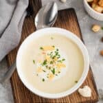 Overhead image of cauliflower cheese soup in a white bowl - 9