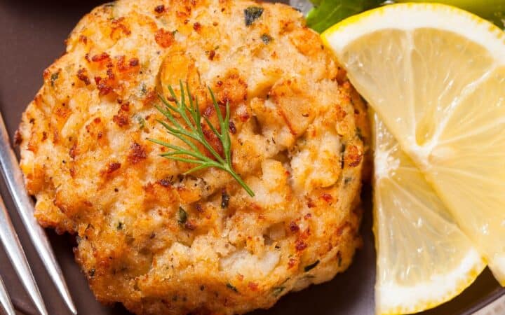 Overhead image of fish cakes on a plate with lemon and broccoli