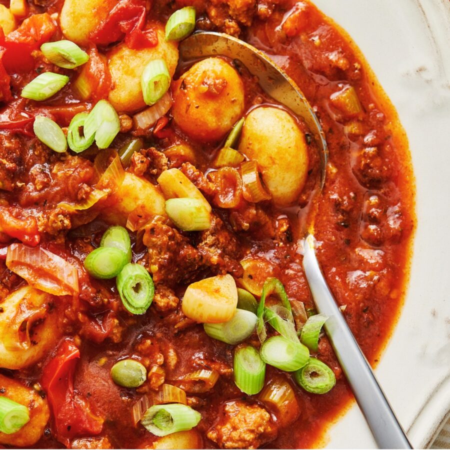 Overhead image of Gnocchi Bolognese in a white bowl with a spoon