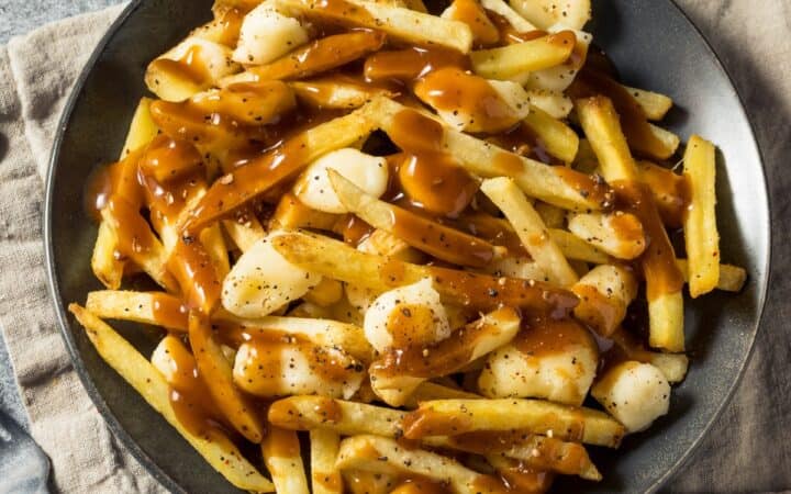 Overhead image of homemade poutine on a black plate