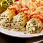 Close up image of three pieces of cheese manicotti covered in marinara sauce - 8