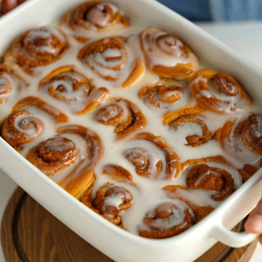 Orange Rolls with glaze in a white baking dish