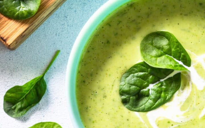 Close up image of Spinach Soup with chopped spinach next to it