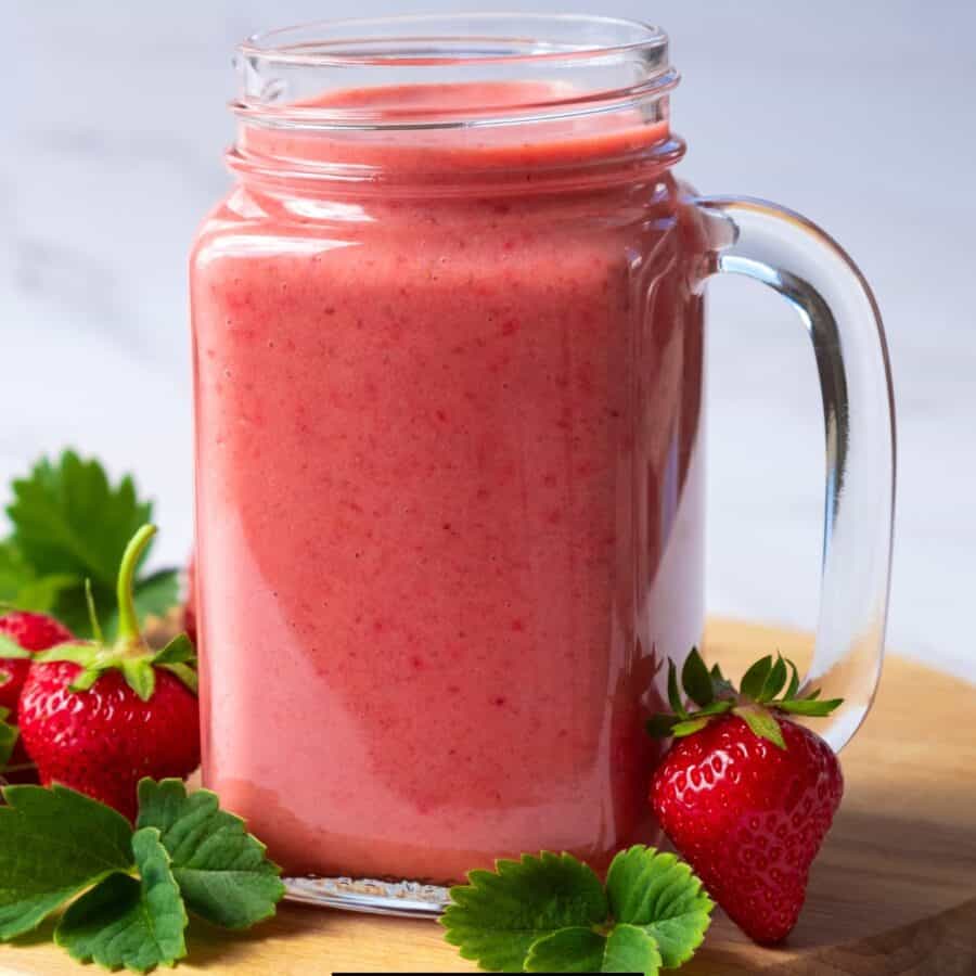 Strawberry Smoothie in a glass mug with strawberries to garnish