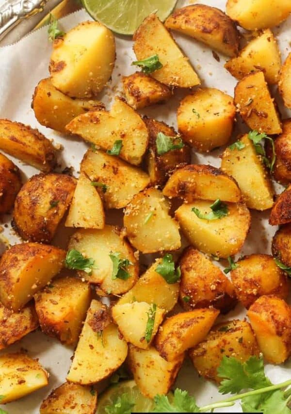 Overhead image of air fryer breakfast potatoes on a white plate with herbs