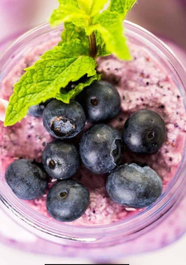 overhead image of a blueberry smoothie with mint and blueberry garnish