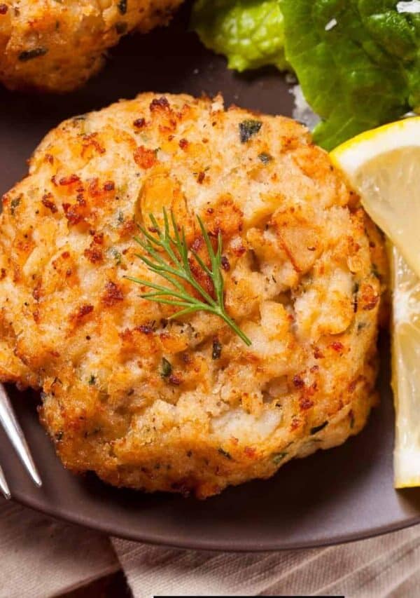 Overhead image of fish cakes on a plate with lemon and broccoli